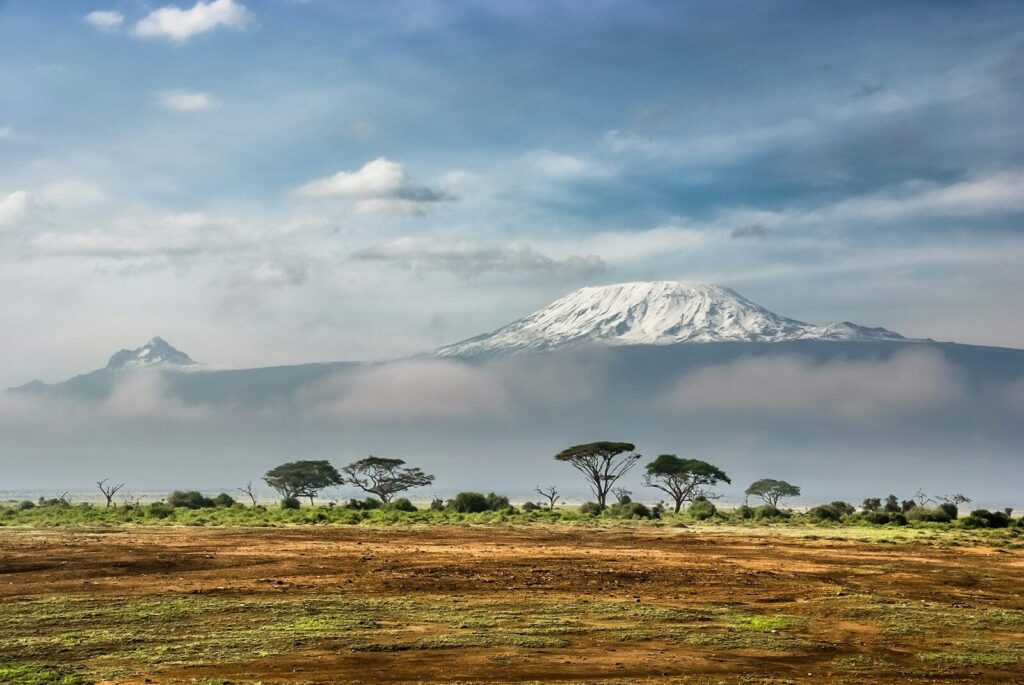 Mount Kilimanjaro with a snow-capped peak above clouds in Amboseli National Park.
